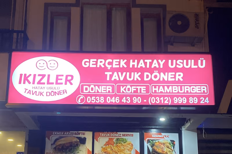 İkizler Döner cephesinde ışıklı tabela ve menü panoları, gece