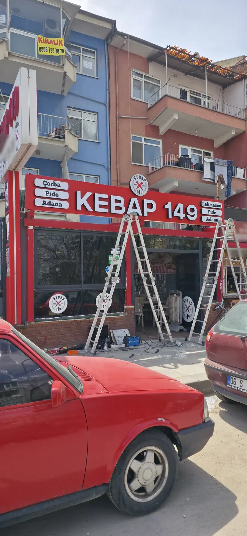 Kebap 149 cephesinde merdivenle sürdürülen tabela montajı