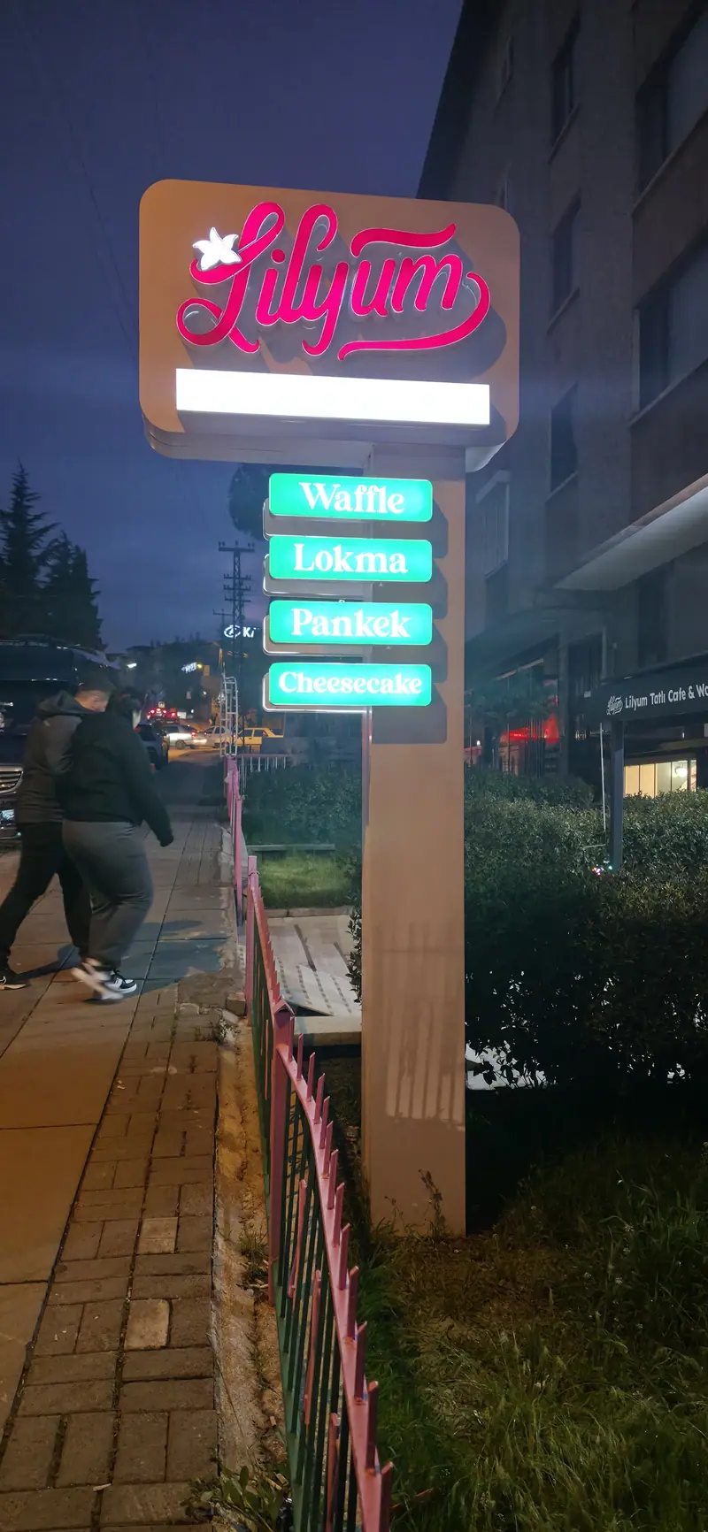 Lilyum işletmesinin yol kenarındaki ışıklı pilon totemi, gece görünümü